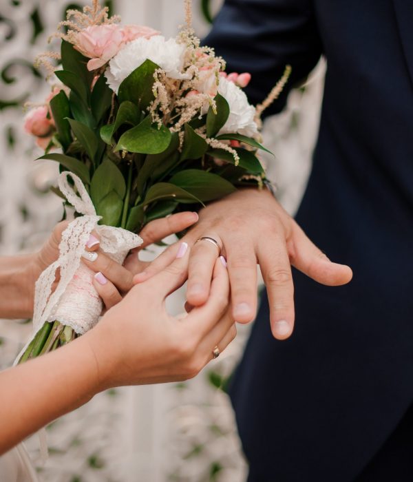 Newlyweds exchanging rings, bride putting the ring on the groom's hand in marriage registry office